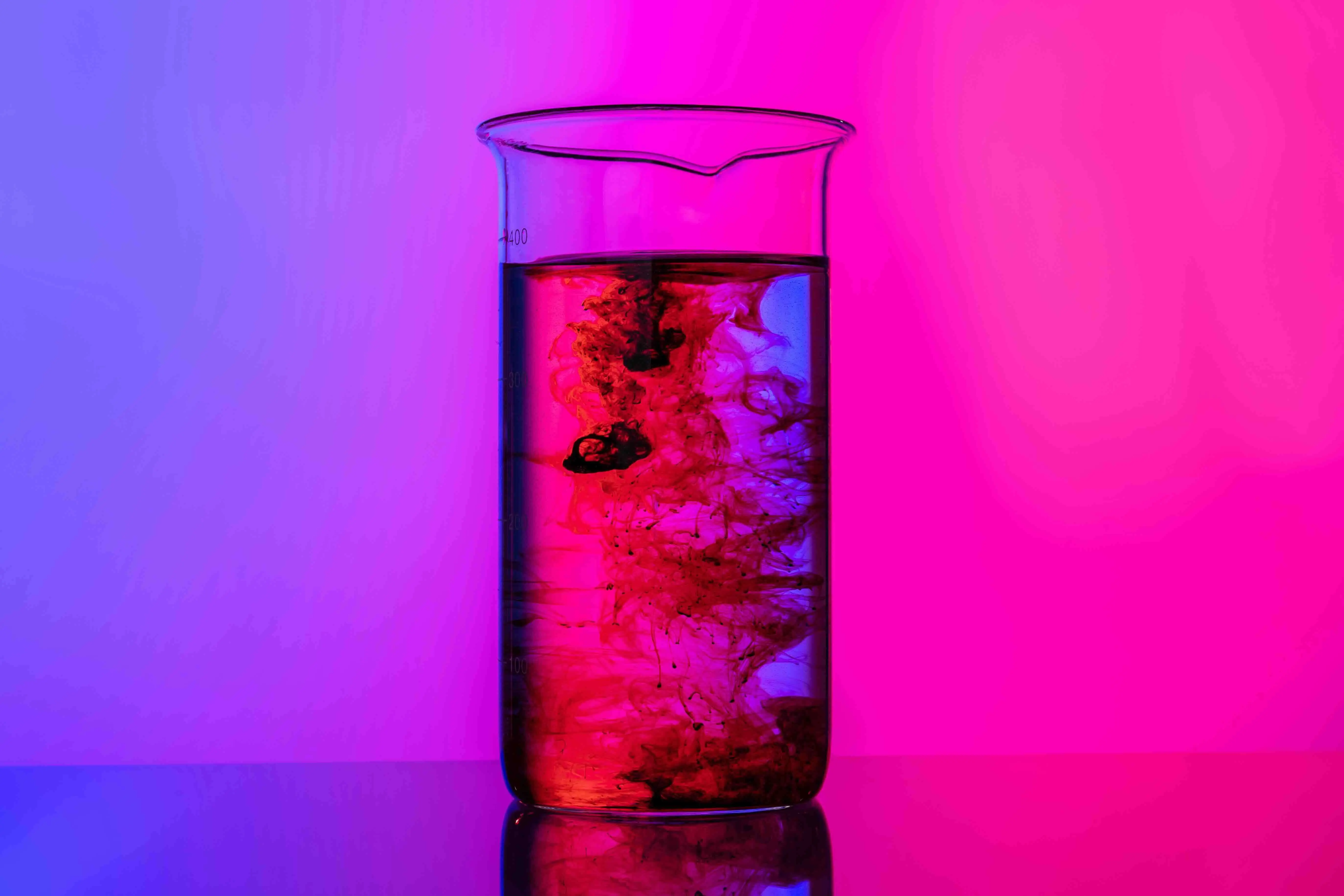 A beaker of liquid switching from pink to purple 