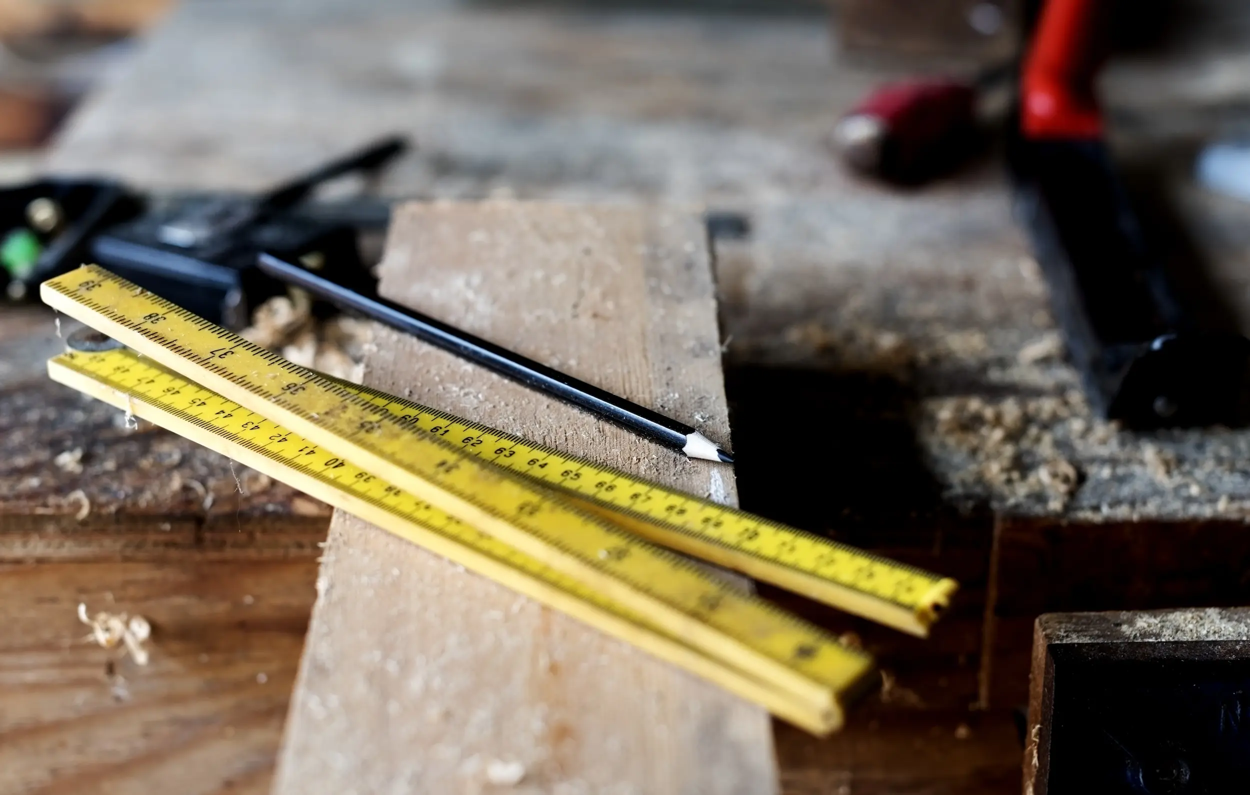 A wood construction table with tools and rulers.