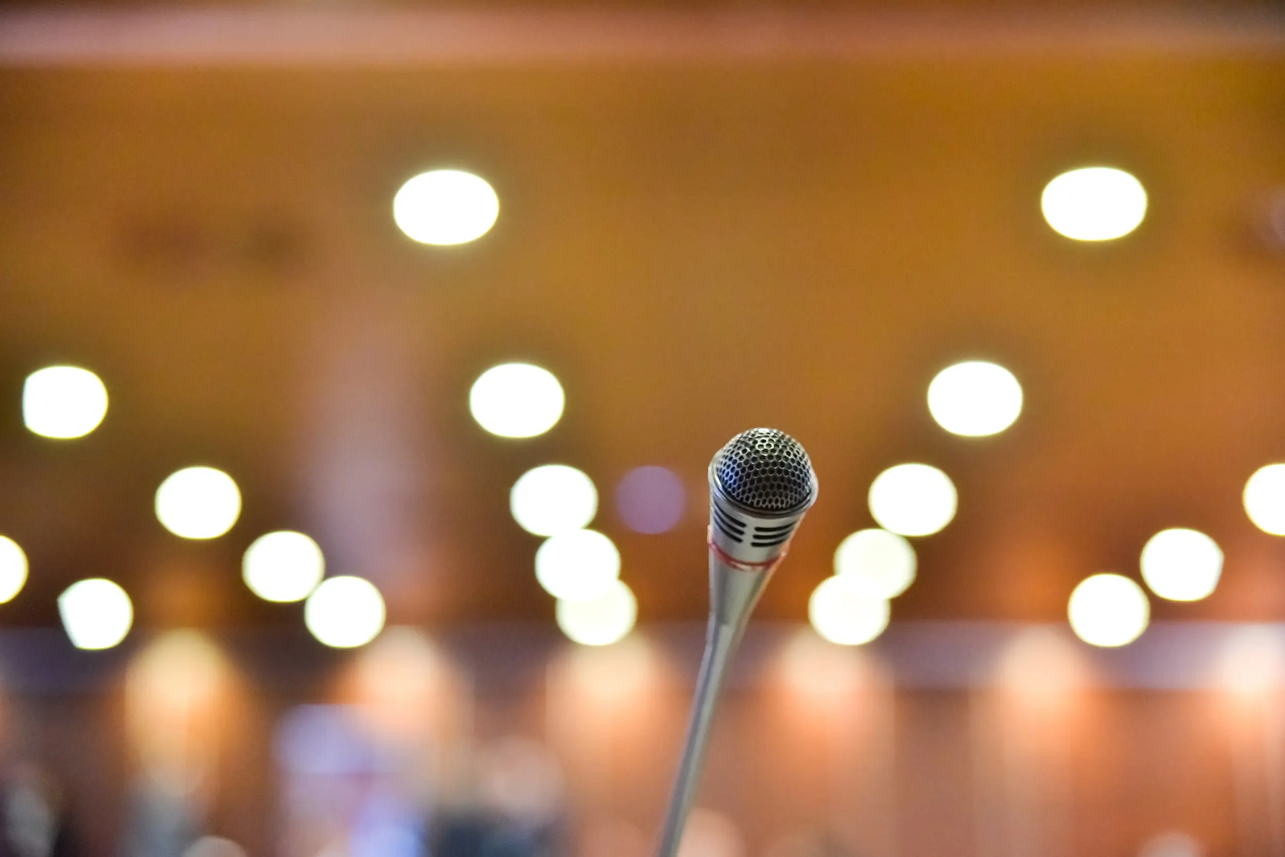 Microphone on the table of a conference room with unfocused background to communicate news