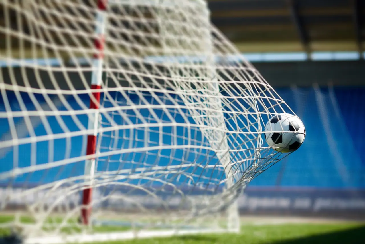 A soccer ball hitting the back of a goal netting