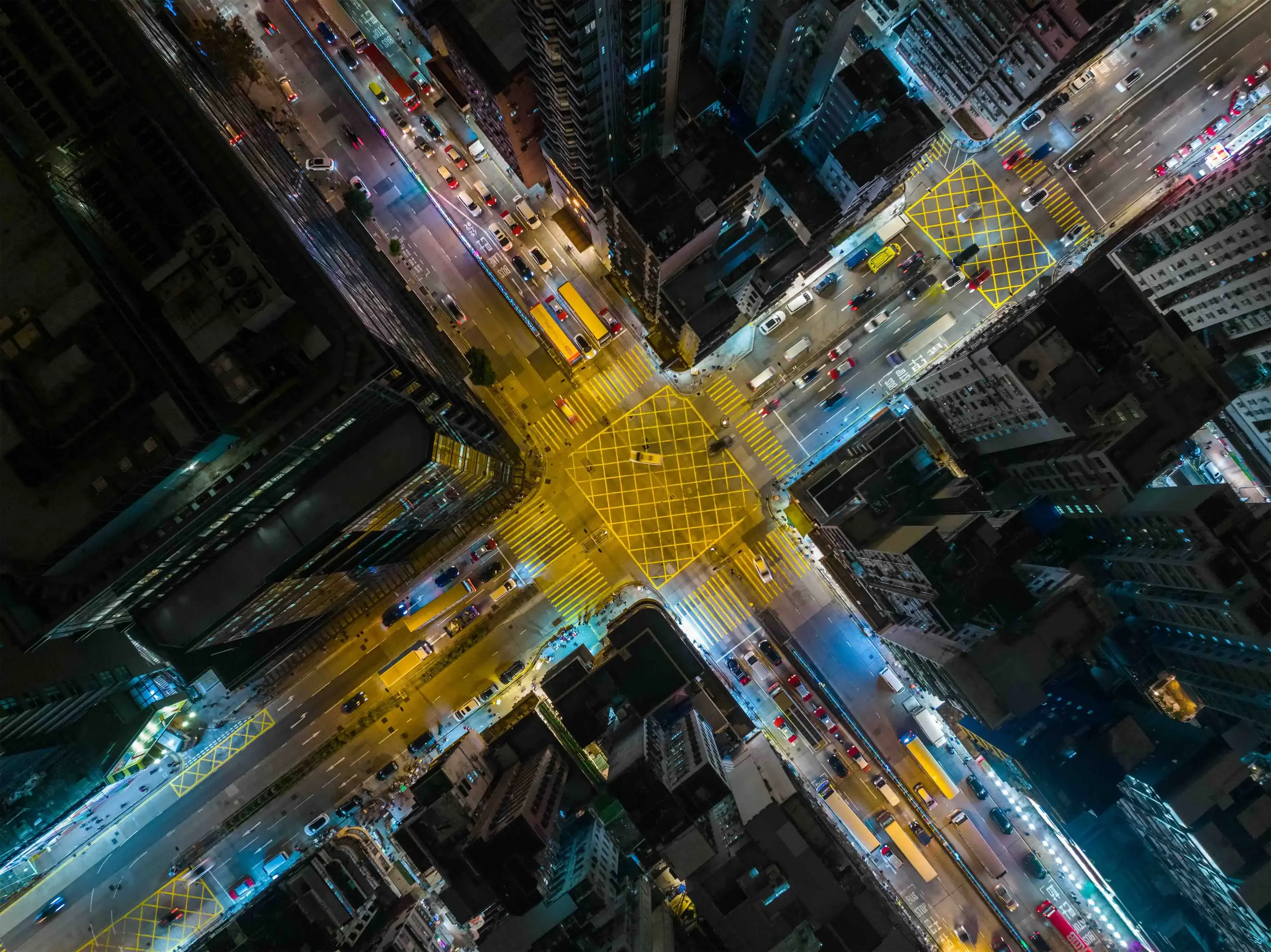 An overhead shot down onto a busy city intersection at night