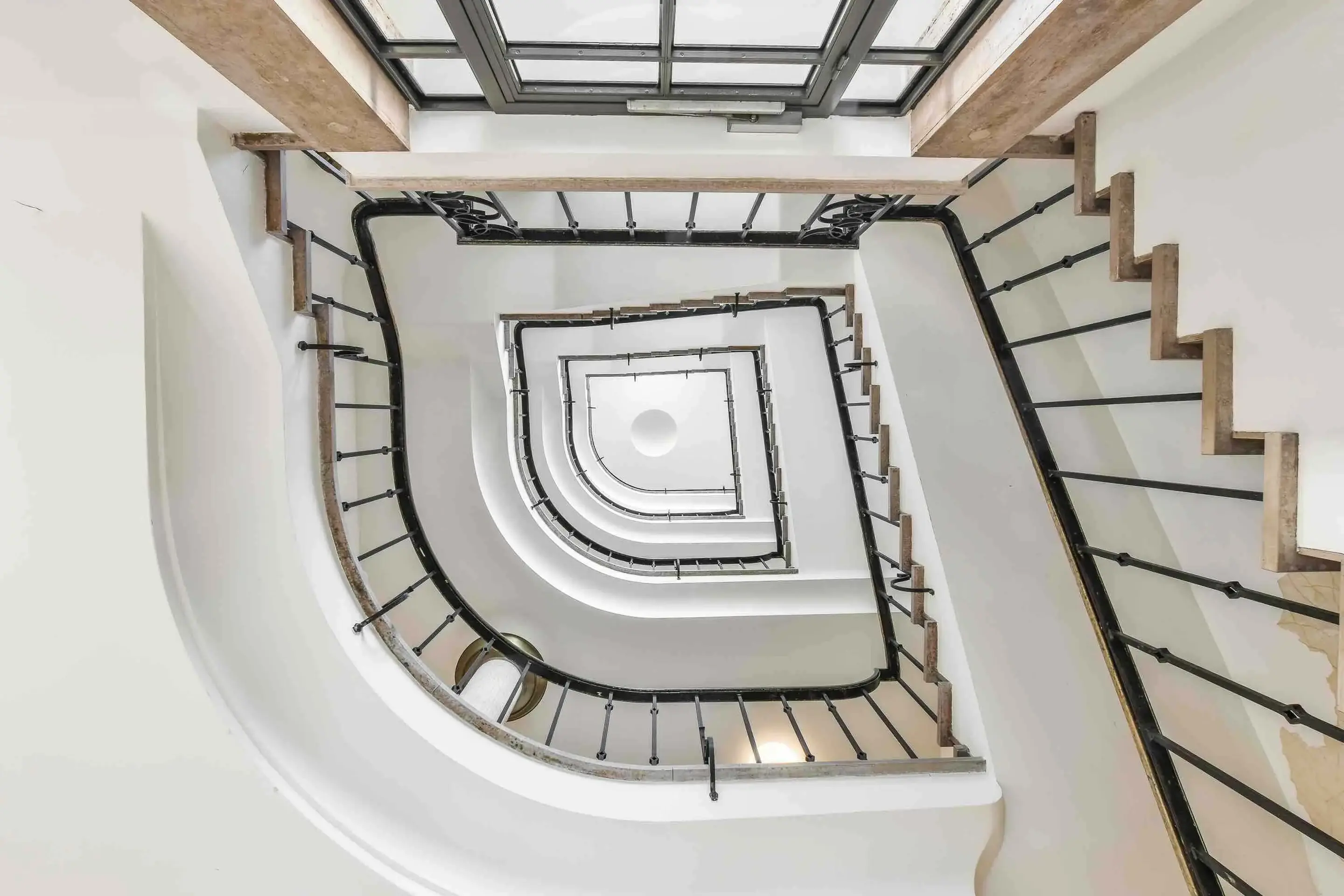 View looking up from the base of a spiral staircase  to represent the steps to using product strategy