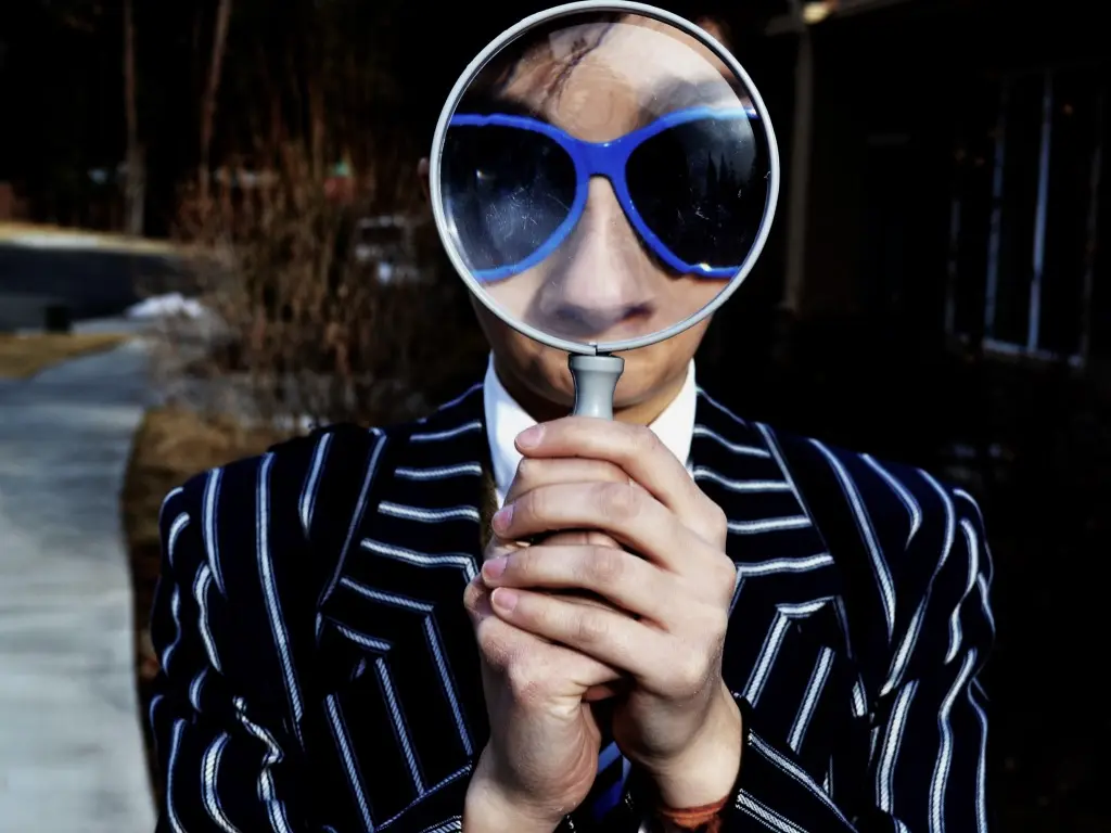 Man peering through magnifying glass