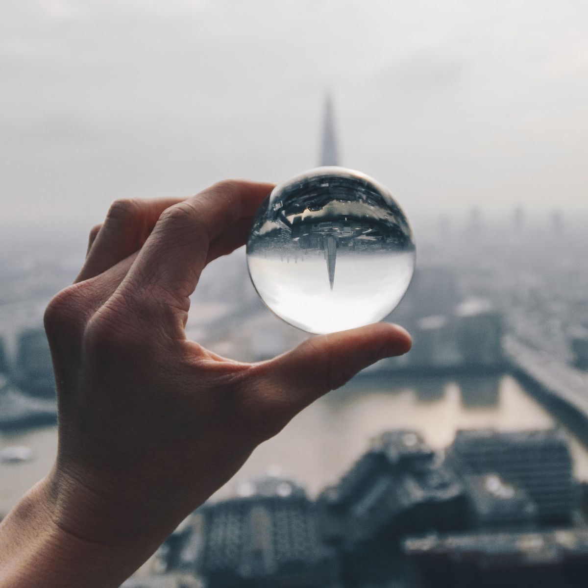 Magnifying ball held up to cityscape
