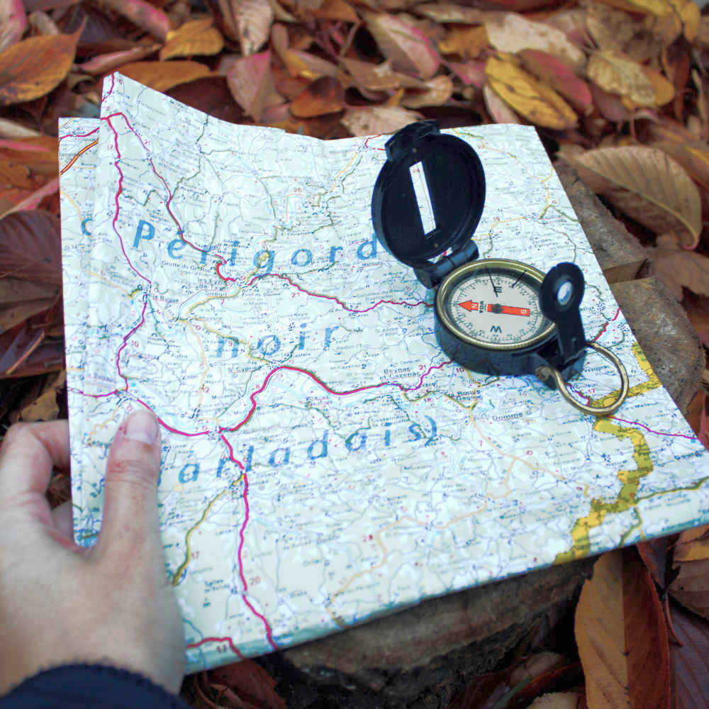 Hand holding map and compass