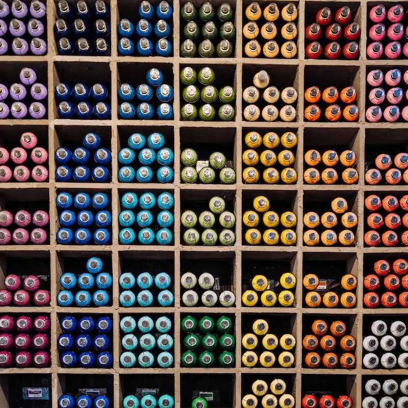 Shelves Filled with Spray Paint Bottles Organized by Color