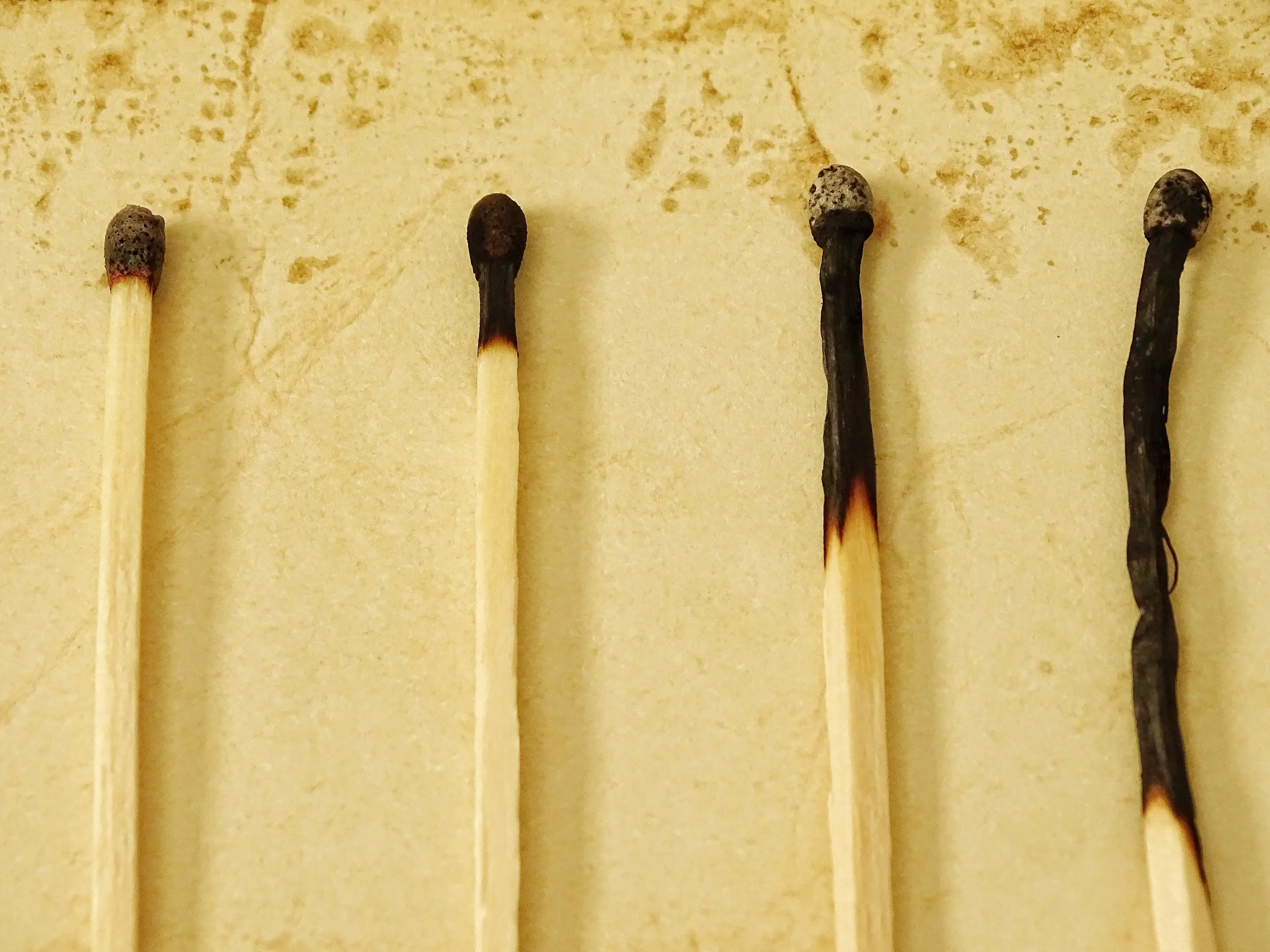 A set of four matches. The left match is the least burnt and they get increasingly more burnt from left to right.