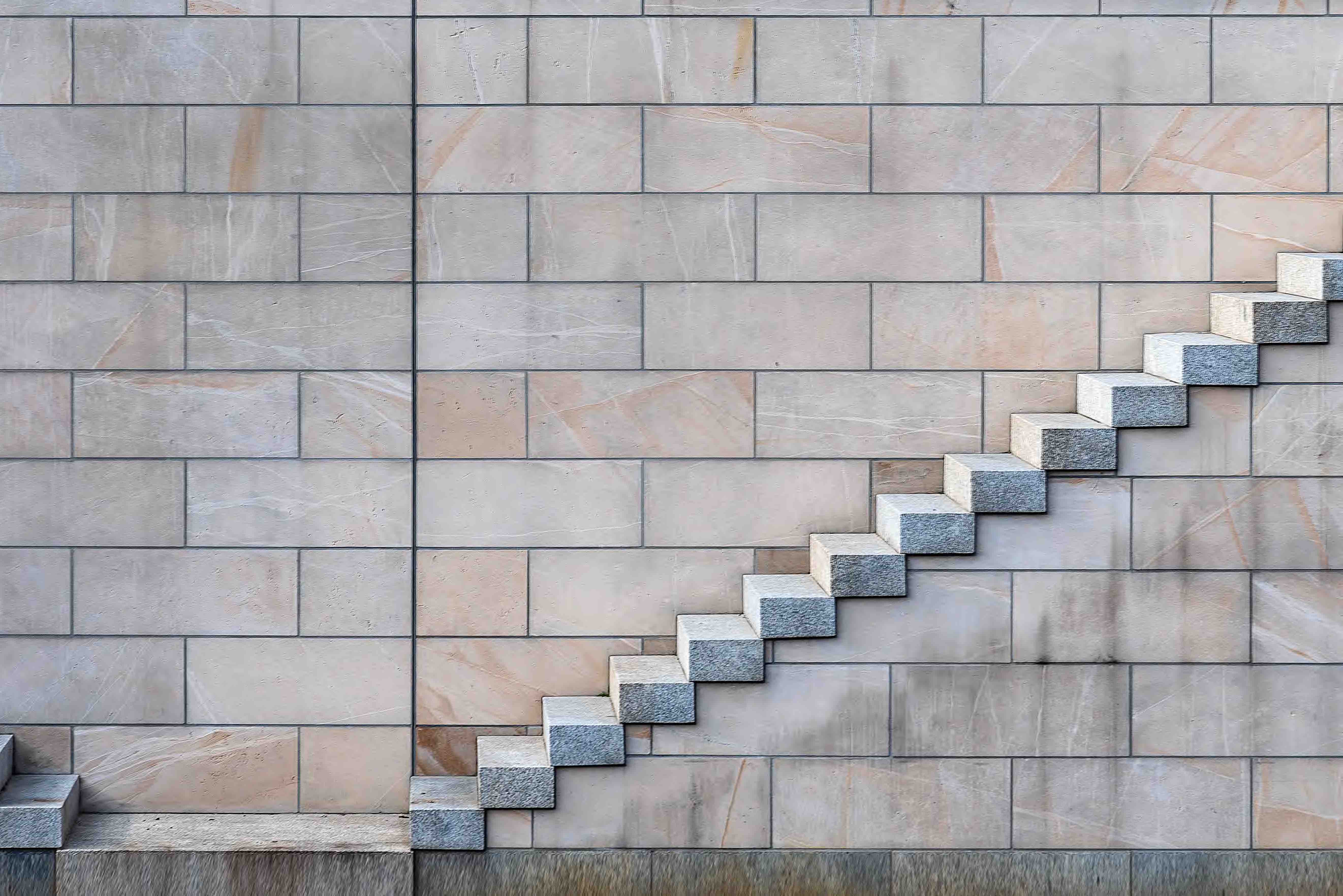 A set of granite stairs set agains a background of multicolored stone tiles
