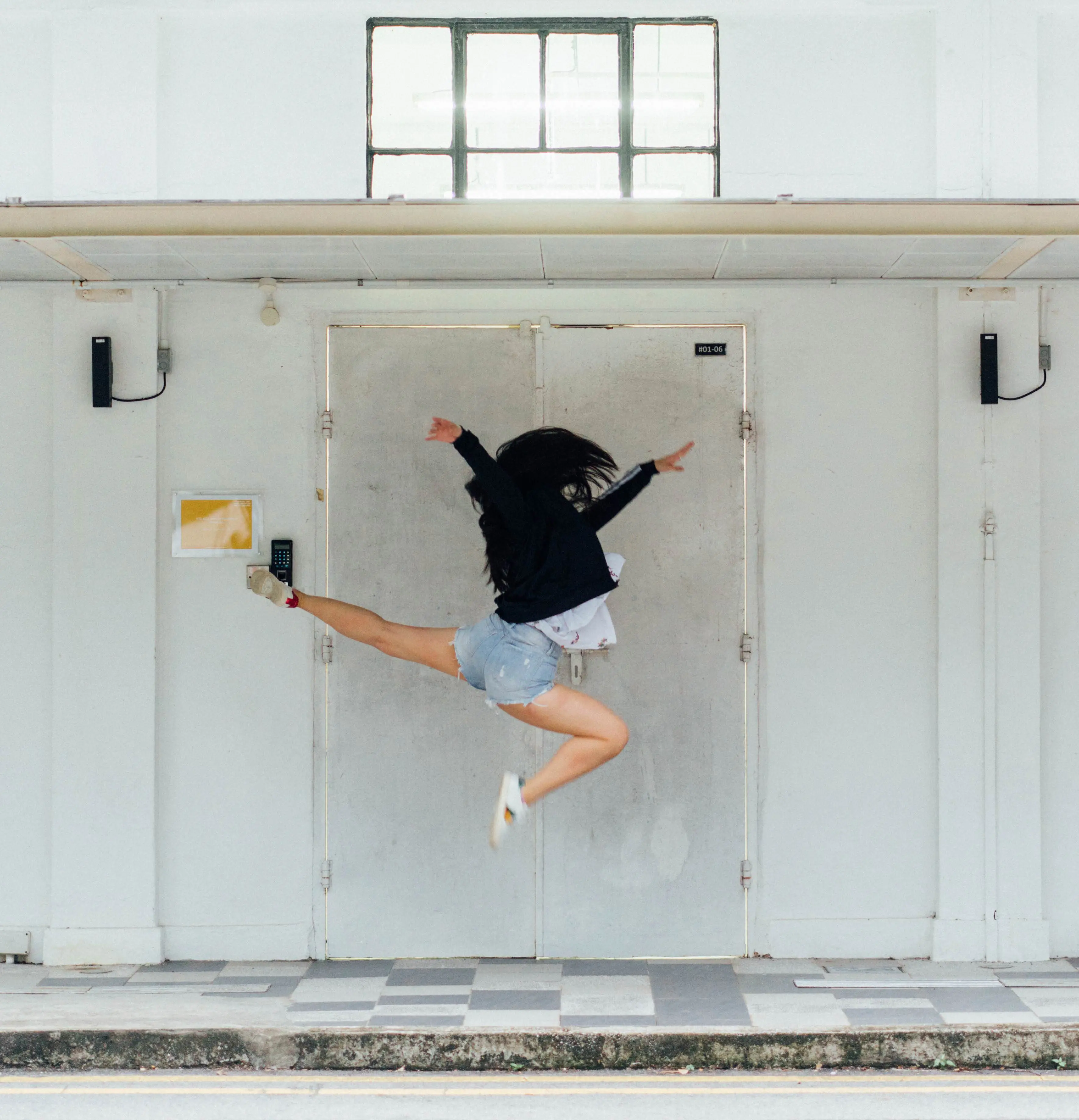 young woman jumping joyously high in air while dancing