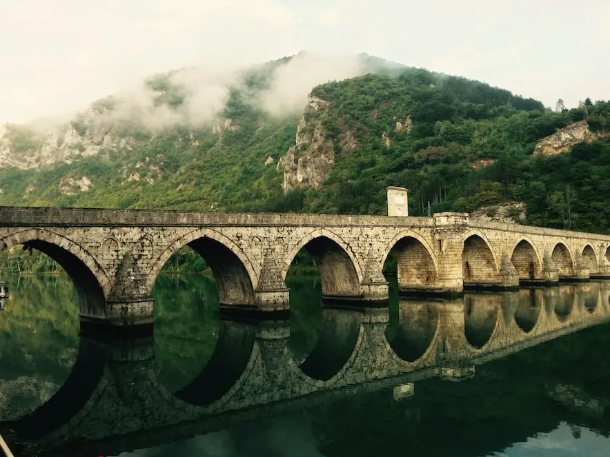 The Mehmed Paša Sokolović Bridge is a stone bridge in Višegrad, Bosnia and Herzegovina, and was completed in 1577. Photo by Torsten Muller, found at https://unsplash.com/photos/tfoqHmi-MOg