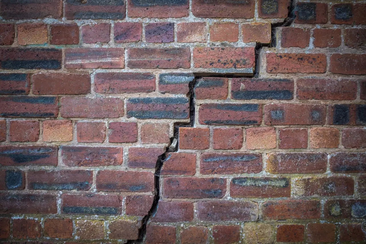 A brick wall with a crack running from top to bottom 