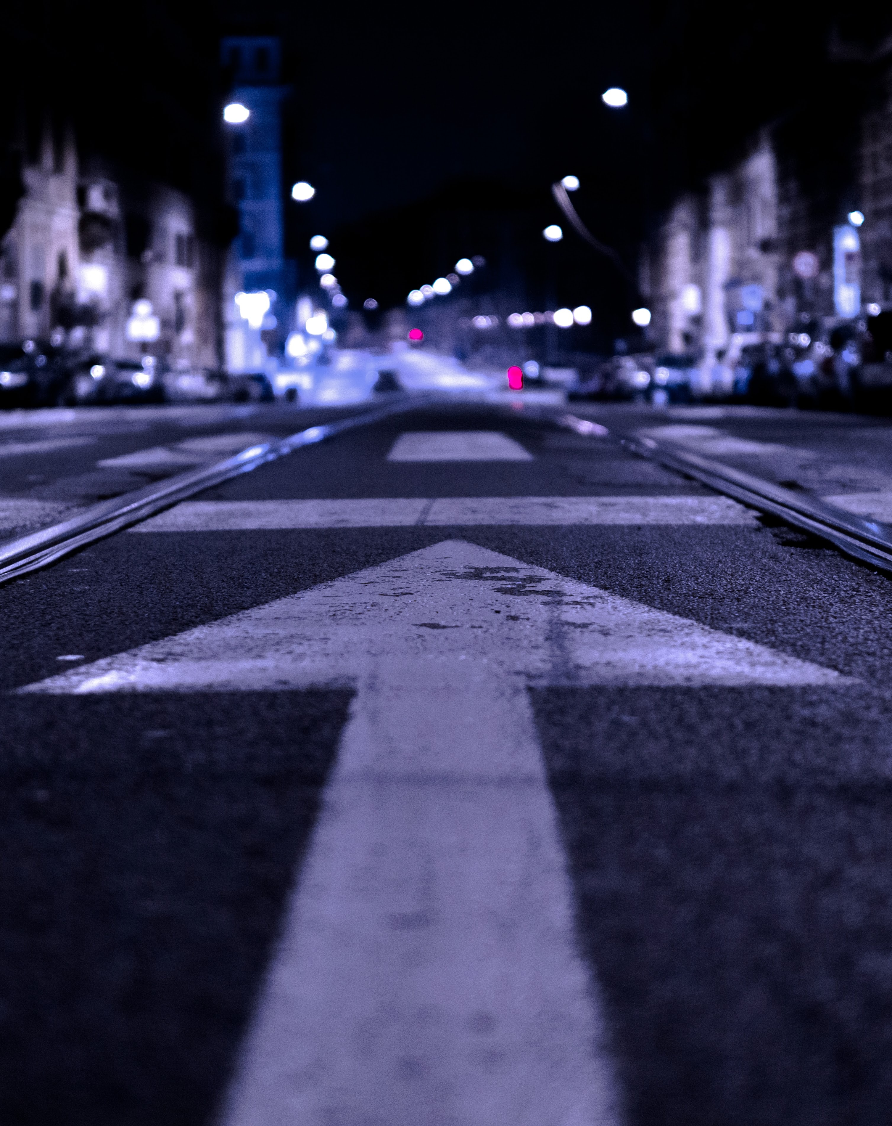 Photograph of street at night with arrow pointing forward.